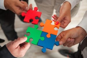 37470361 - group of business people assembling jigsaw puzzle and represent team support and help concept in office.